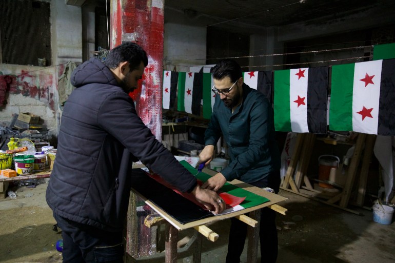 Two men prepare a Syrian opposition flag