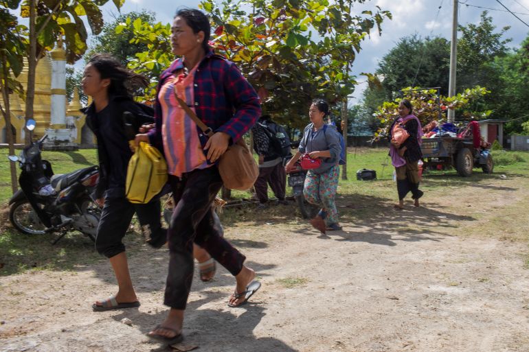 Women running in Loikaw amid fighting between the military and armed groups opposed to the 2021 coup. The women look worried.
