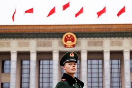 A paramilitary police officer stands guard in front of the Great Hall of the People, in Beijing, China, on March 4, 2024 [Tingshu Wang/ Reuters]