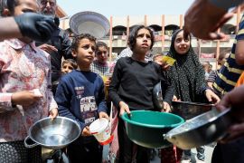 Palestinian children gather to receive meals from the charity World Central Kitchen in Deir el-Balah in the central Gaza Strip, on May 1, 2024 [Ramadan Abed/Reuters]