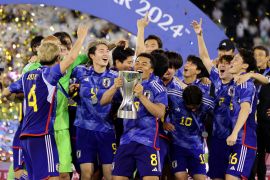 Japan&#039;s Joel Fujita celebrates with the trophy and teammates after winning the AFC U23 Asian Cup final [Ibraheem Al Omari/Reuters]