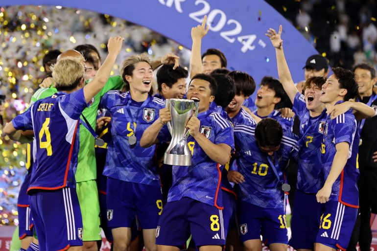 Japan's Joel Fujita celebrates with the trophy and teammates after winning the AFC U-23 Asian Cup final