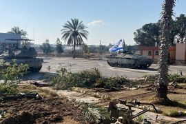 Israeli military vehicles are seen on the Palestinian side of the Rafah Crossing in the southern Gaza Strip on May 7, 2024 [Handout by the Israeli army via Reuters]
