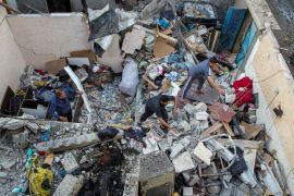 Palestinians inspect a house damaged in an Israeli strike [Hatem Khaled/Reuters]