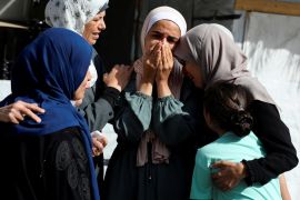 A family mourns loved ones killed in Israeli attacks in Deir el-Balah in the central Gaza Strip on Sunday [Ramadan Abed/Reuters]