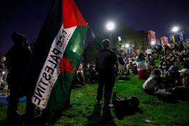Supporters of the pro-Palestinian protesters sit on stairs leading to an encampment as students demonstrate on the campus of the University of California, Los Angeles (UCLA). [Etienne Laurent/AFP]