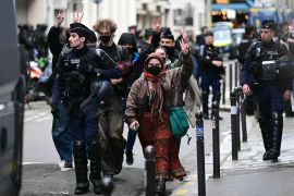 Protesters flash the sign of victory as they are escorted away by French police during the evacuation of a pro-Palestine protest at Sciences Po university in Paris [Miguel Medina/AFP]