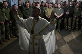 Servicemen of the 24th brigade of Ukrainian Army attend the Easter service in an undisclosed location in the Donetsk region. [Genya Savilov/AFP]