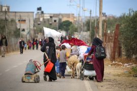 Displaced Palestinians in Rafah in the southern Gaza Strip carry their belongings as they follow an evacuation order by the Israeli army and leave [AFP]