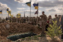 Azov Brigade fighters pay their respects at the grave of Nazary Gryntsevych, a Ukrainian soldier who was killed on the battlefield in Mariupol [Roman Pilipey/AFP]