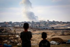 Boys watch smoke billowing during Israeli strikes east of Rafah [AFP]
