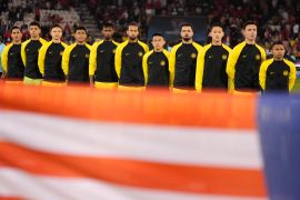 Players of team Malaysia stand for their national anthem before the start of the Asian Cup Group E soccer match between Malaysia and Bahrain at Jassim bin Hamad Stadium in Doha, Qatar, on Saturday, January 20, 2024 [Thanassis Stavrakis/AP Photo]