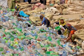 Labourers in Pakistan sort through empty bottles at a plastic recycling factory in Hyderabad, Pakistan on April 30, 2023 [Pervez Masih/AP]