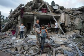 Palestinians look at the destruction after an Israeli airstrike in Deir al Balah, Gaza Strip [Abdel Kareem Hana/AP Photo]