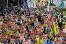 Workers hold placards reading &#039;The regime has no honeymoon&#039; during a May Day rally in Taipei, Taiwan. [Chiang Ying-ying/AP Photo]
