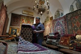 Ali Faez at his carpet shop in the traditional bazaar of the city of Kashan, about 245km (152 miles) south of the capital, Tehran. [Vahid Salemi/AP Photo]