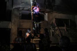 Palestinian Civil Defence members evacuate survivors of the Israeli bombardment on a residential building of Abu Alenan family in Rafah, early Saturday [Ismael Abu Dayyah/AP Photo]