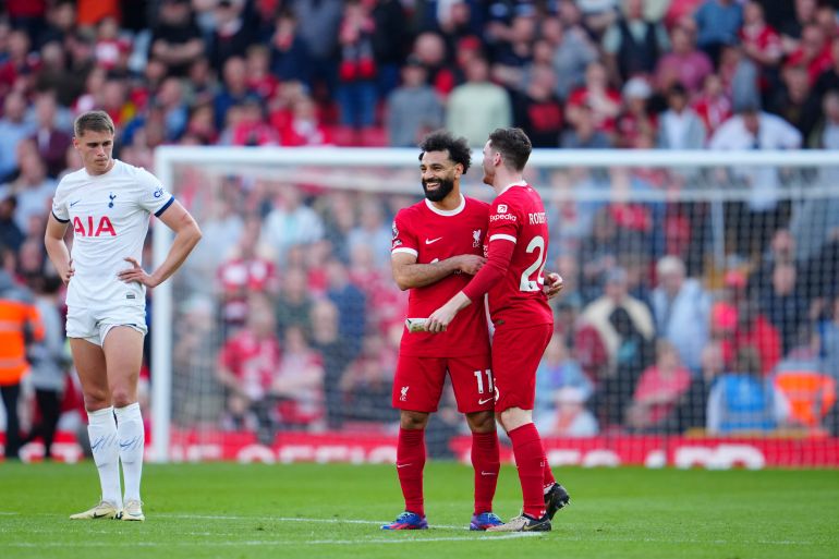 Liverpool's Andrew Robertson, right, and Mohamed Salah, center, celebrate at the end of the English Premier League soccer match between Liverpool and Tottenham Hotspur at Anfield Stadium in Liverpool, England, Sunday, May 5, 2024. (AP Photo/Jon Super)