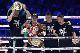 Naoya Inoue of Japan celebrates with his champion belts after defeating Luis Nery of Mexico in the fight for the unified WBA, WBC, WBO and IBF super bantamweight world titles in Tokyo [Hiro Komae/AP]