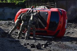 Ukrainian servicemen turn over a damaged car at the scene of a Russian missile attack in Zaporizhzhia, Ukraine, Wednesday, May 8, 2024. (AP Photo/Andriy Andriyenko)