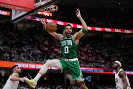 Boston Celtics forward Jayson Tatum dunks between Cleveland Cavaliers guard Max Strus, left, and guard Caris LeVert during Game 3 [Sue Ogrocki/AP]
