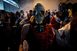 Protesters wear masks to avoid pepper spray and tear gas being used by police in Georgia&#039;s capital, Tbilisi [Stephan Goss/Al Jazeera]