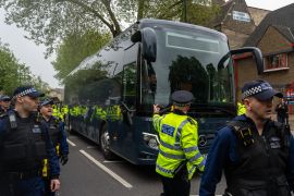 Police officers surround a bus that was to be used to transport migrants from a hotel on May 2, 2024 in Peckham, south London. Protesters at the scene vowed to stop the removals [Carl Court/Getty Images]