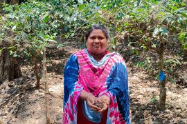Araku Valley farmer Nava Roja holding coffee beans that originate on her land, but that fetch her less than 1 percent of what they are sold for in the international export market [Gurvinder Singh/Al Jazeera]
